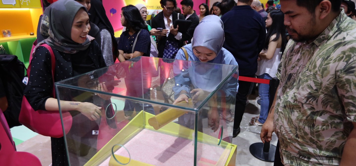 Visitors gathered around a lit display case