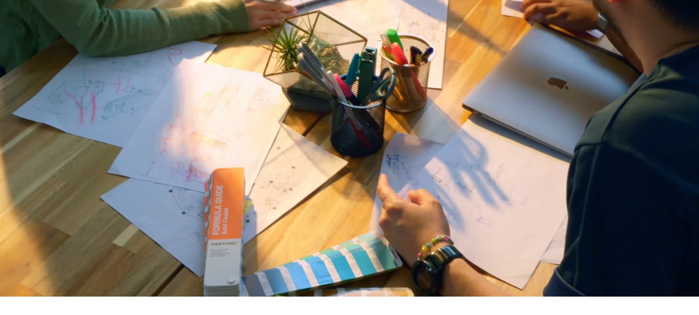 Hands sketching layouts on paper during a design session