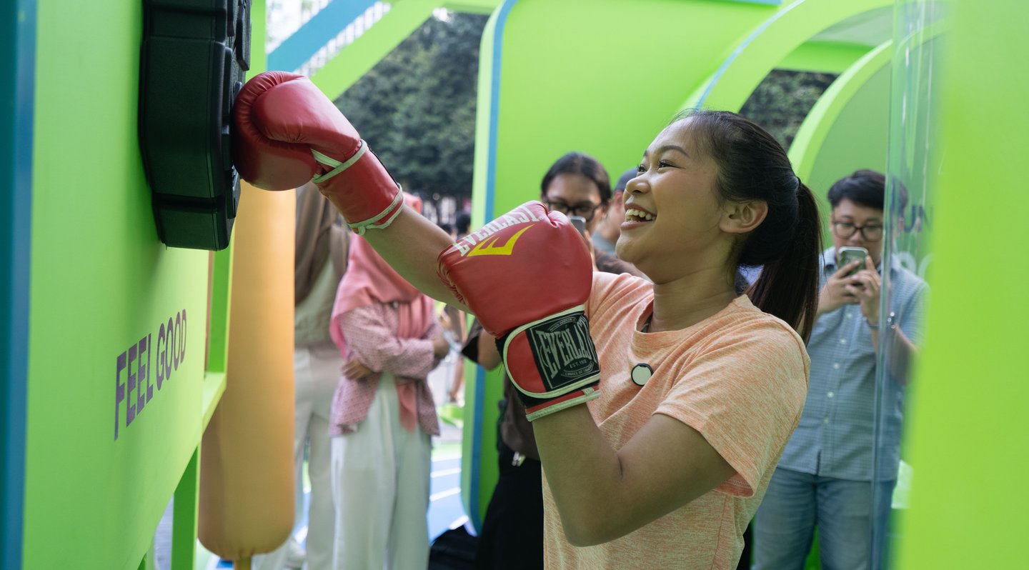 A visitor punching a speed-test machine with a red boxing glove