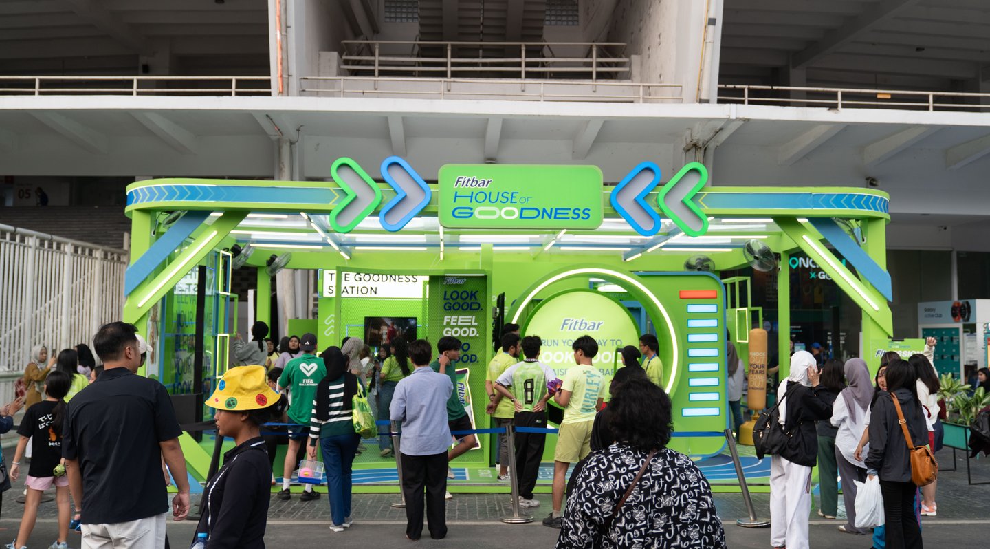 Visitors queuing at a green outdoor pop-up entrance