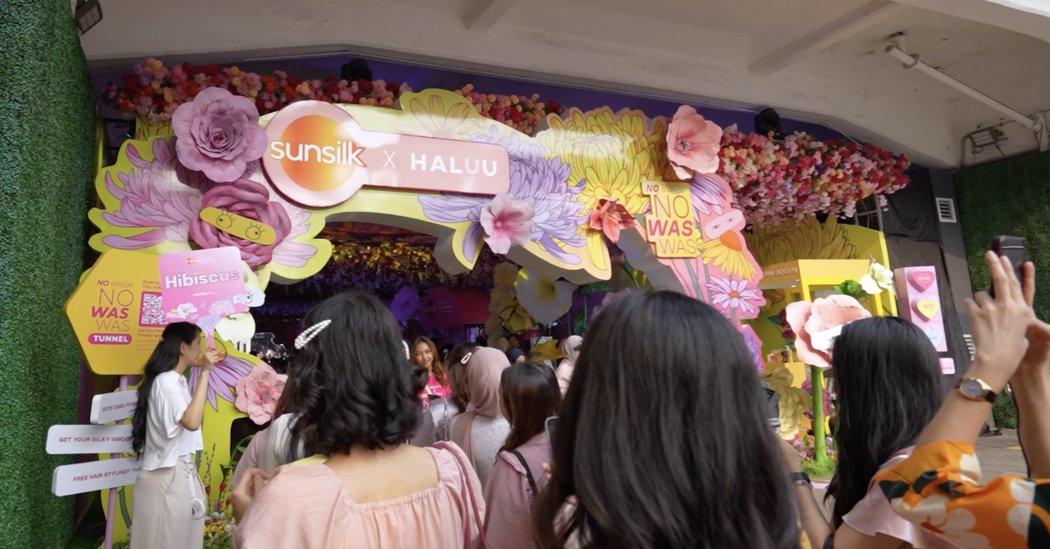 Visitors gathered at a floral photo wall