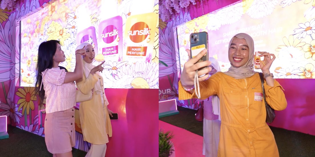 Two visitors taking a selfie at a pink lit installation